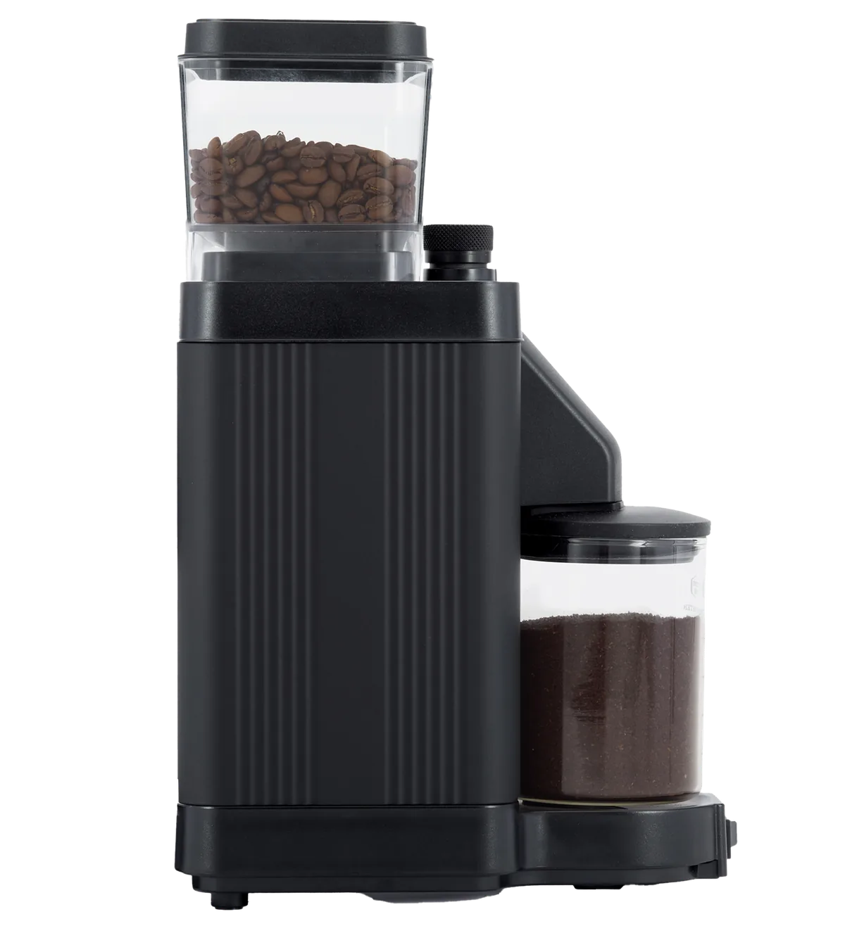 Moccamaster KM5 i matt svart sett fra siden, med bønnebeholder øverst og glass med malt kaffe foran