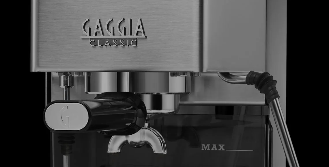 Nærbilde av bryggegruppen på Gaggia Classic E24 med filterholderen festet og G-logoen på håndtaket