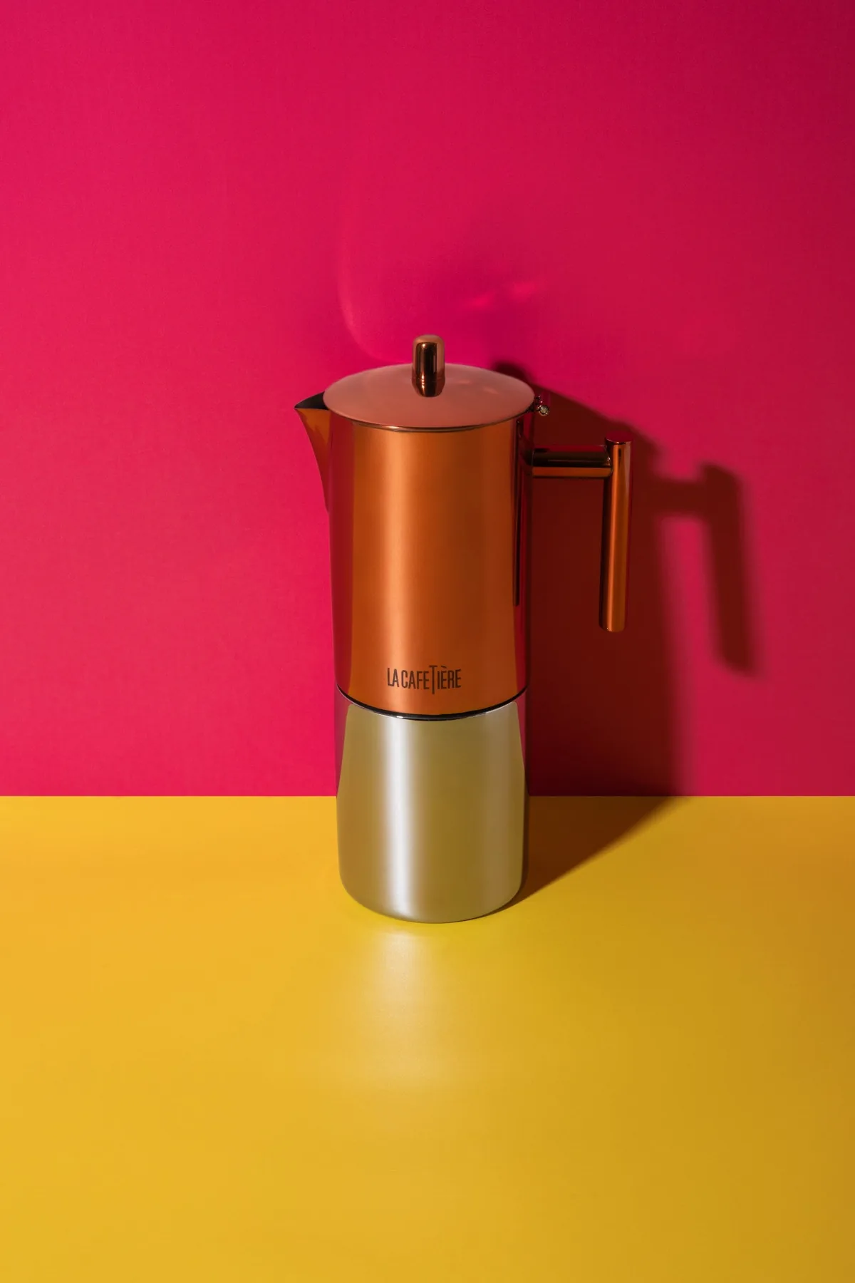 La Cafetière 600 ml med logoen på den kobberfargede overdelen, foran en rosa vegg