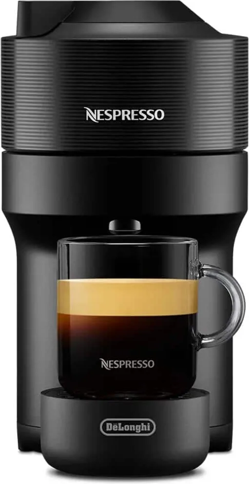 Nespresso Vertuo Pop i svart sett rett forfra, med et glass kaffe på koppholderen